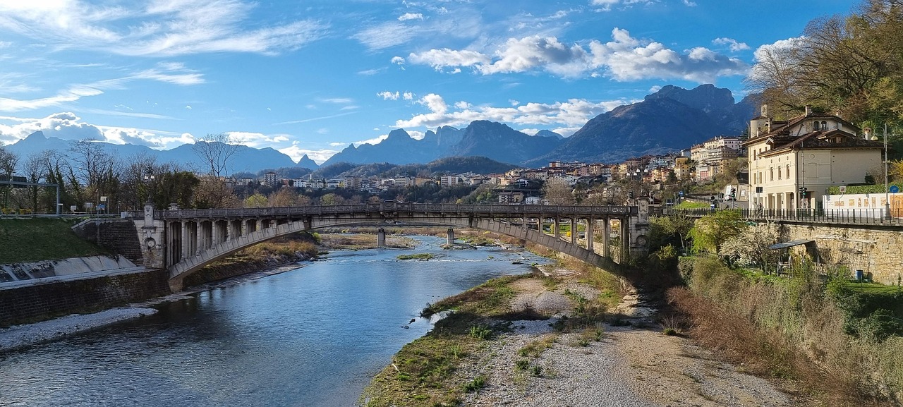 Vista del ponte romantico in una pittoresca città italiana, circondato da architettura storica e natura.