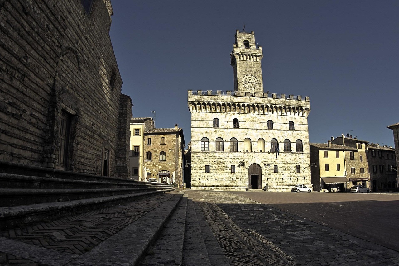Piazza storica in una città toscana, con architettura affascinante e visitatori che ammirano il panorama.