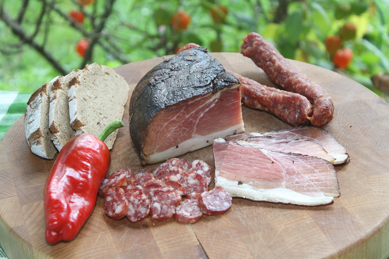 Speck affumicato appeso in un caratteristico borgo dell'Alto Adige, circondato da legno di faggio.