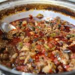 Piatto tipico del borgo con ingredienti freschi e colorati, servito in un contesto rustico.