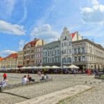 Vista panoramica di una tranquilla piazza europea con alberi e panchine, ideale per il relax.