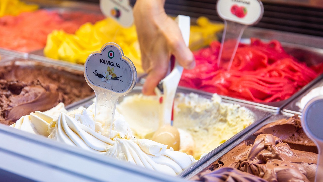 Gelato artigianale servito in un cono, con vista su una piazza italiana affollata di turisti.
