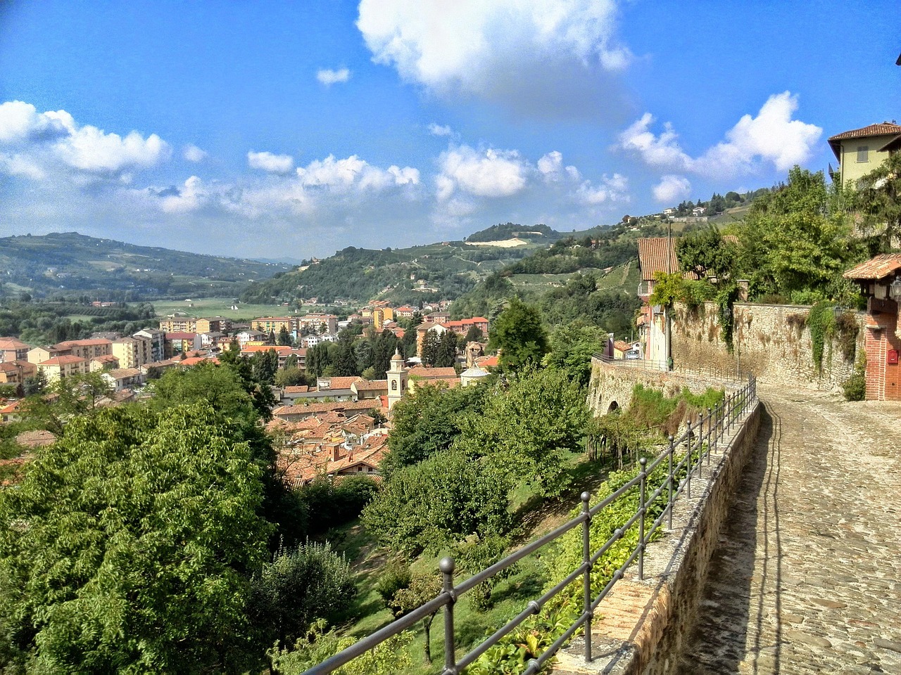 Borgo piemontese con vista panoramica sulle colline e il cielo azzurro.