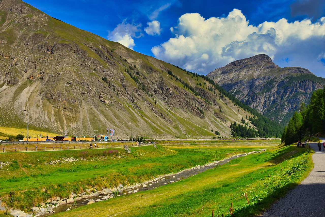 Panorama mozzafiato della Valtellina, con montagne e valli verdi sotto un cielo sereno.