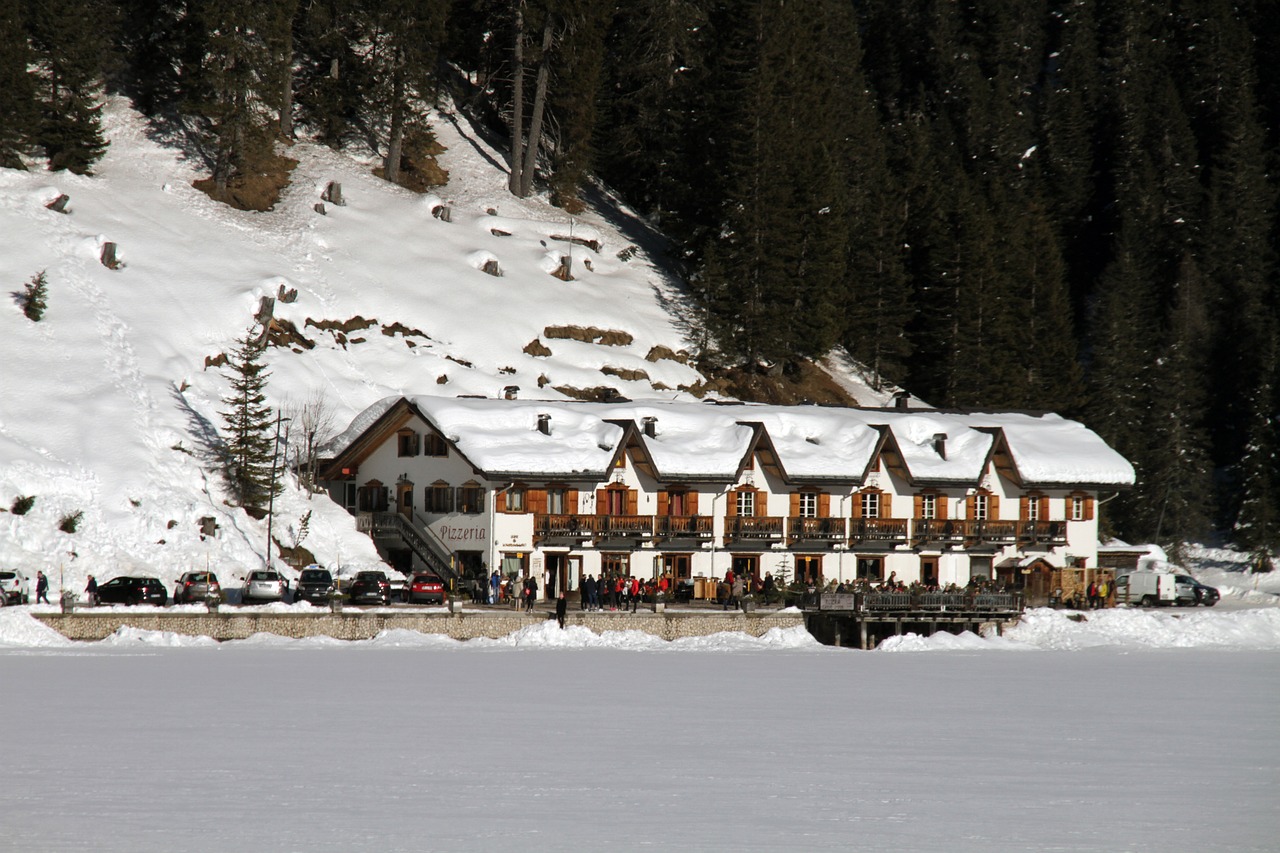 Lago di Braies al tramonto, circondato da montagne e foresta, ideale per una fuga nella natura.